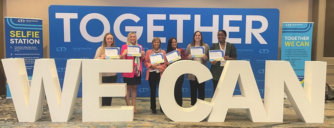 HCA Healthcare colleagues standing near large letters that read "Together we can." 
