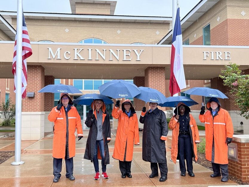 HCA Healthcare colleagues standing outside the McKinney Police Department in the rain. 
